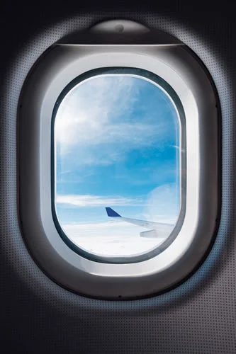 Janela oval de um avião durante voo